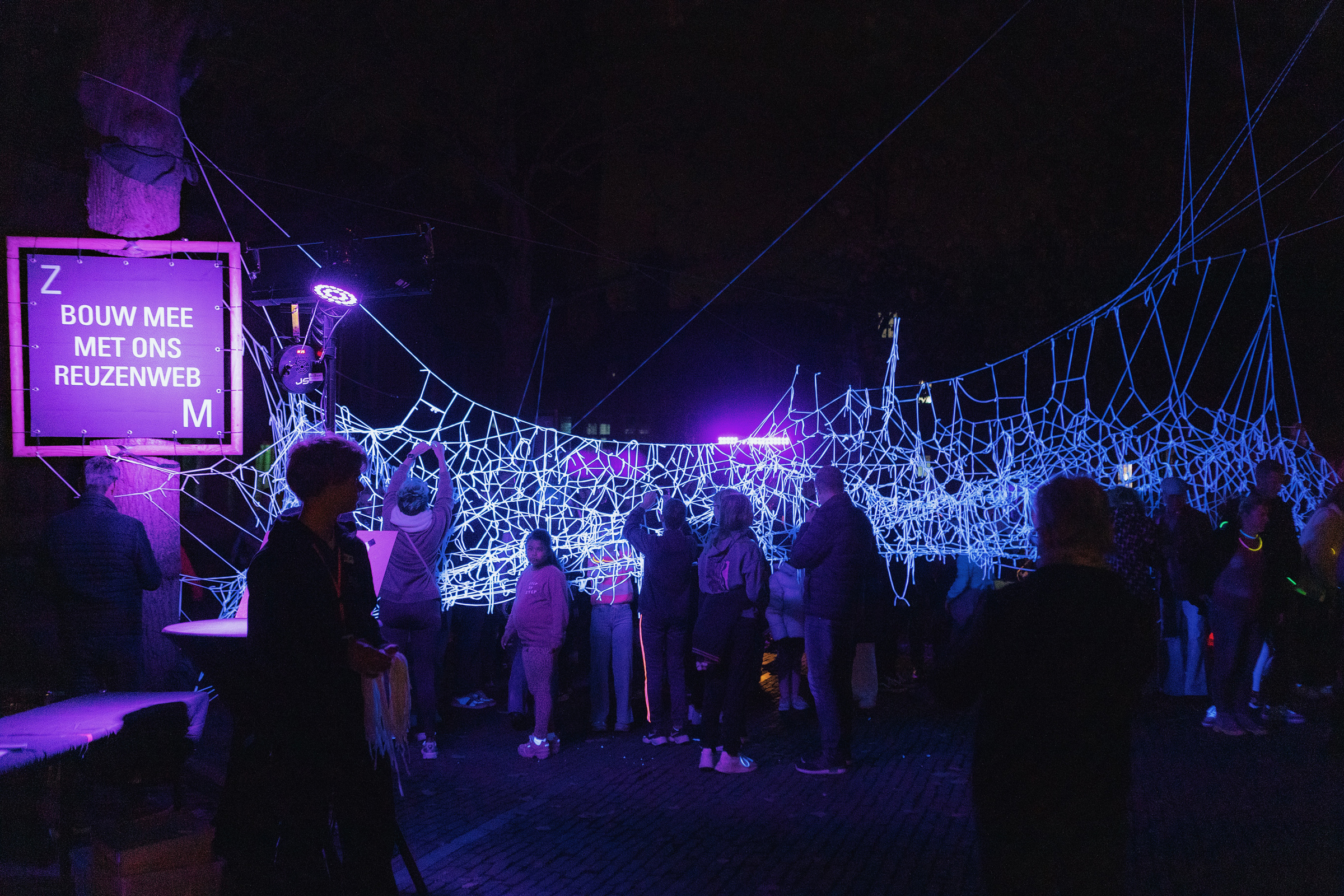 Bezoekers van de N8vdN8 actief met het maken van een Glow in the dark reuzenweb.